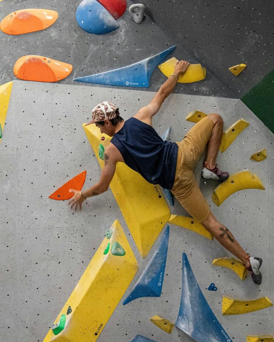 A climber bouldering at an indoor gym