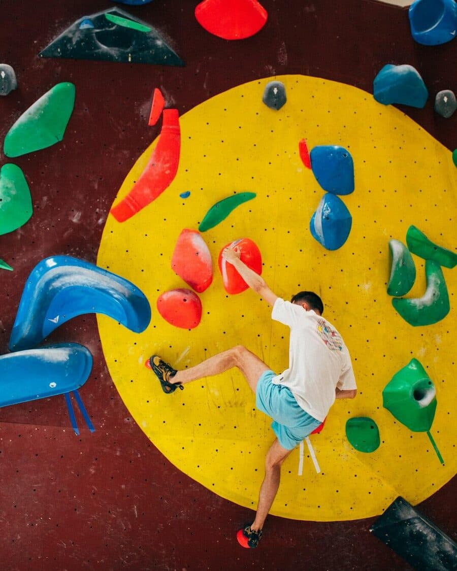 A climber bouldering at an indoor gym